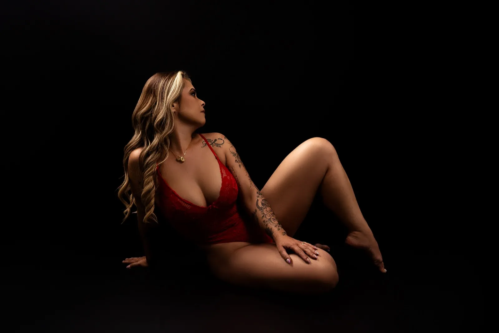 Pose sentada no chão com apoio de braço, tronco girado e queixo baixo