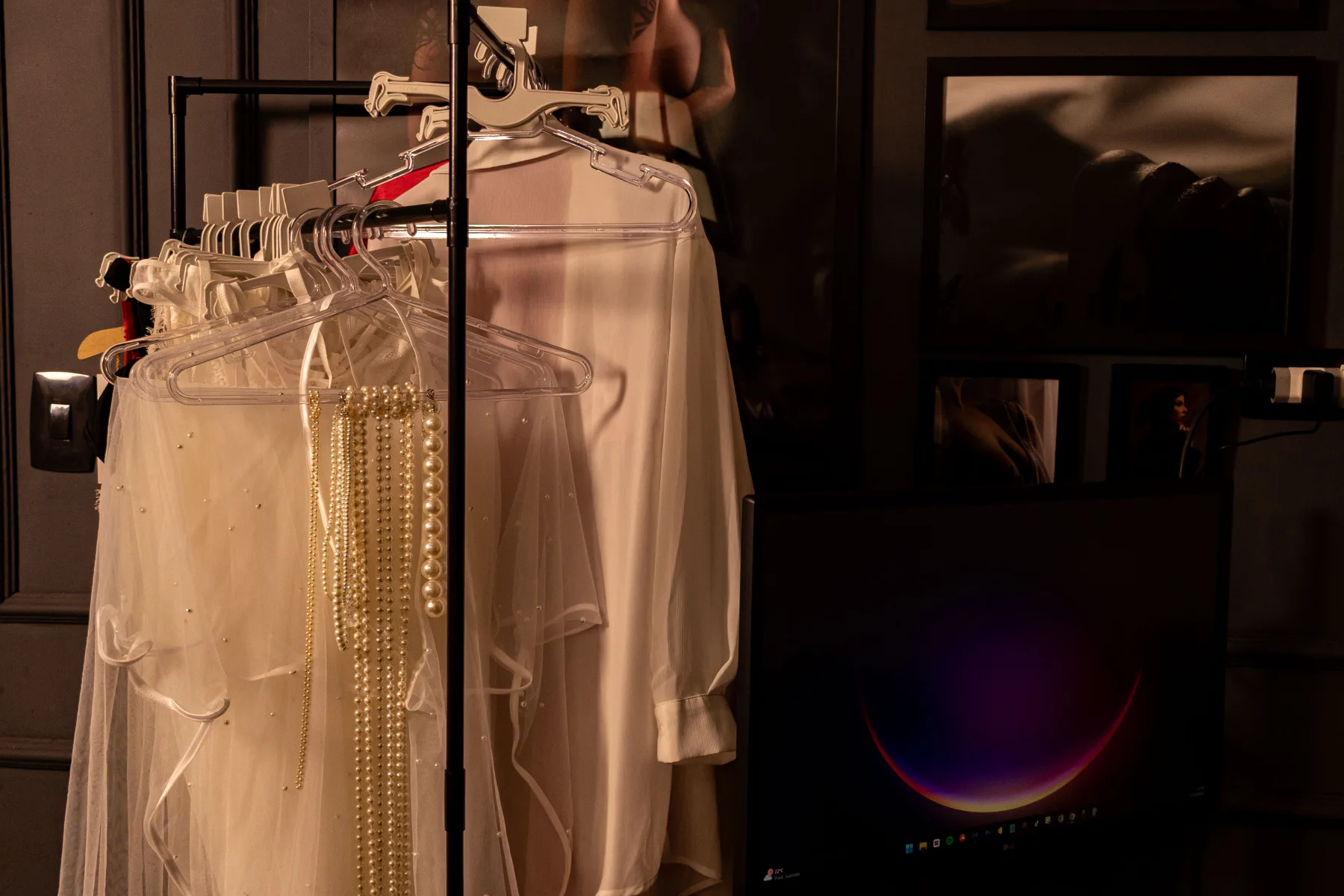 Closet de figurinos do estúdio com peças de lingerie e looks pendurados